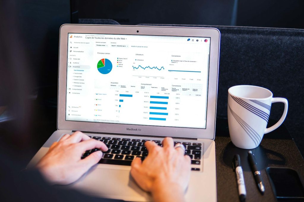 Laptop con un panel de analítica web junto a una taza de café