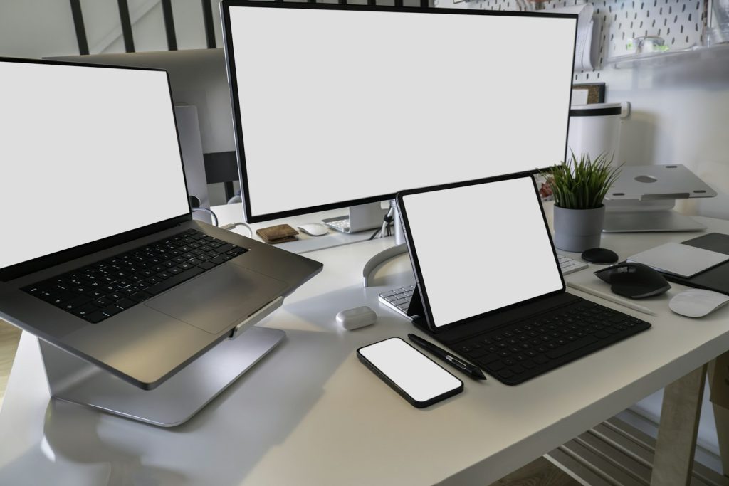 Escritorio con laptops, tableta y celular: el diseño responsive adapta un sitio web a cada pantalla