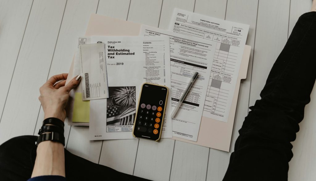 Emprendedor revisando gastos con calculadora y papeles